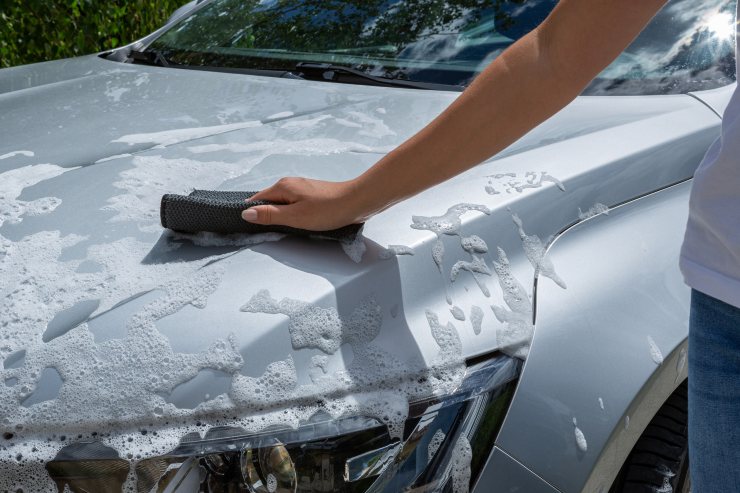 Une Jeune Femme Nettoyant Et Polissant Sa Voiture Avec Un Chiffon En  Microfibre Jaune Concept De Voiture En Prenant Soin